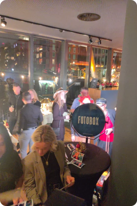Fotobox-Party auf einem Firmenevent in der Frankfurter Botschaft Gäste eines Firmenevents feiern eine Party und posieren für Fotos an einer beleuchteten Fotobox mit dem Schriftzug "FOTOBOX".