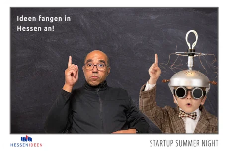 Fotobox-Layout der Startup Summer Night in Hessen Ein Mann und ein Junge posieren für ein Foto vor einem schwarzen Hintergrund, beide haben eine Idee (eine Glühbirne über dem Kopf). Das Bild ist mit dem Text "Ideen fangen in Hessen an!" und dem Logo "HESSENIDEEN" versehen.