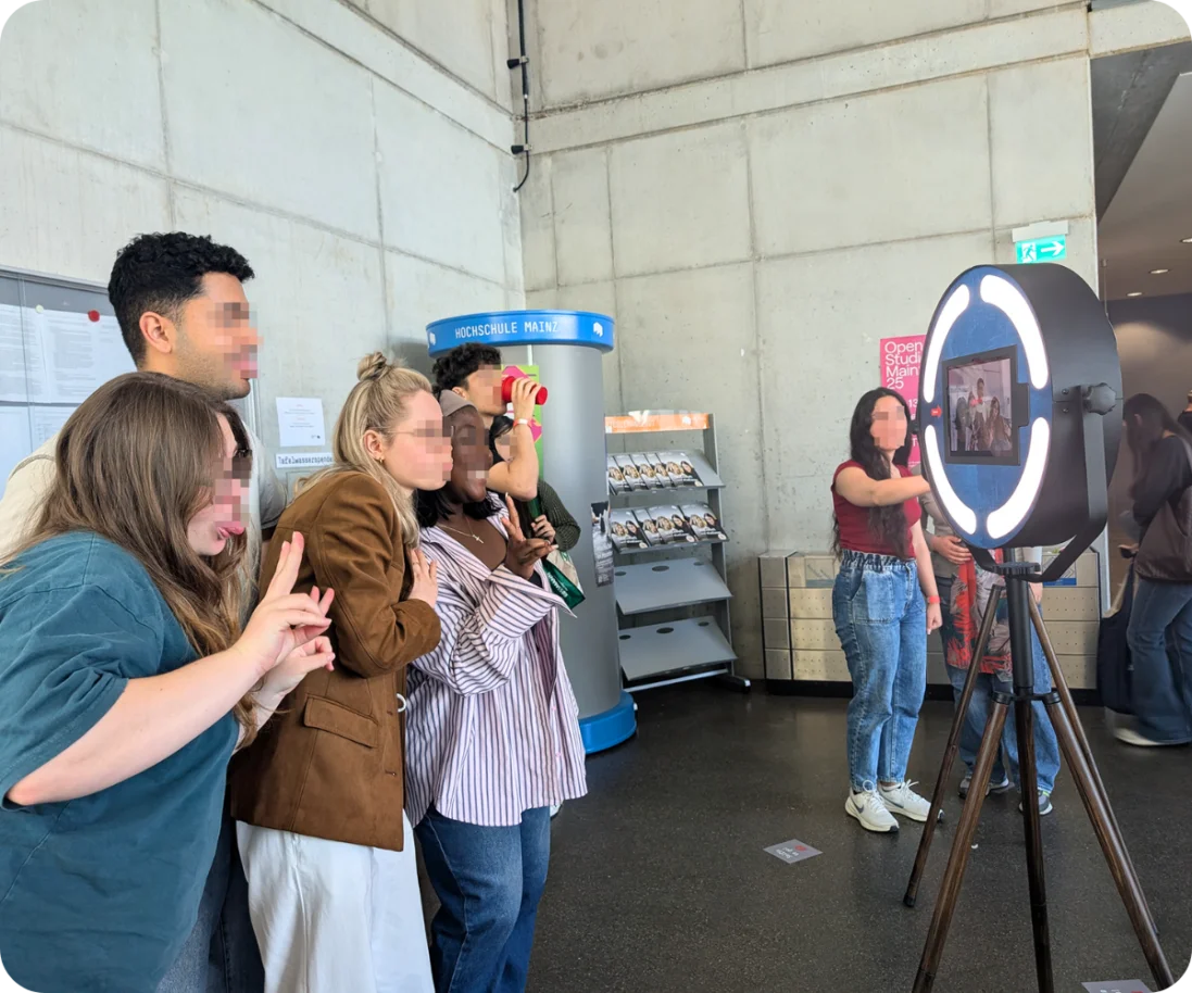 Fotobox auf den Unternehmertagen der Hochschule Mainz Eine Gruppe von Studenten posiert lachend und Grimassen schneidend vor einer Fotobox, die auf den Unternehmertagen der Hochschule Mainz steht.