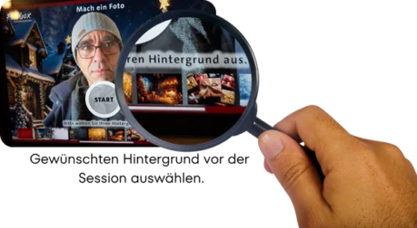 Fotobox: KI-Hintergrund auswählen Eine Hand hält eine Lupe über einem Smartphone-Bildschirm. Der Bildschirm zeigt eine Fotobox-App, auf der ein Mann für ein Foto posiert und verschiedene Hintergründe, wie Geschenke oder einen Kamin, zur Auswahl stehen